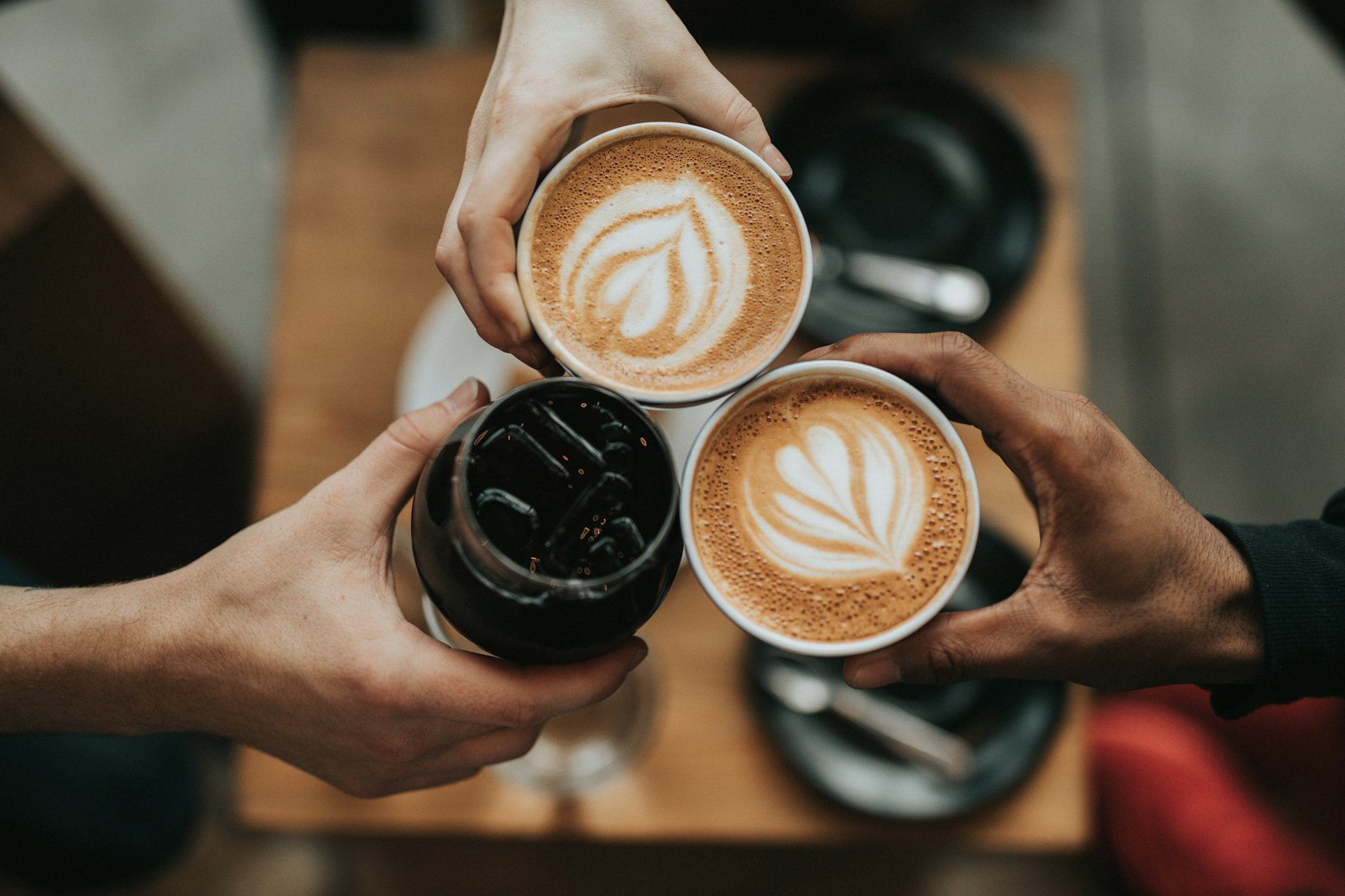 Due cappuccini che si incontrano sopra un tavolo di legno